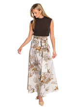 Load image into Gallery viewer, A woman modeling a sleeveless dark brown top and a high-waisted, wide-leg pleated skirt with a brown and beige botanical print, standing against a plain white studio background.