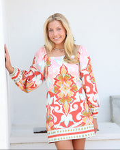 Load image into Gallery viewer, Woman wearing a colorful dress with floral patterns on a white background