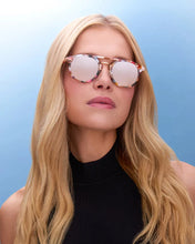 Load image into Gallery viewer, Woman wearing round sunglasses with a light blue background