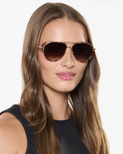 Load image into Gallery viewer, Woman wearing brown aviator sunglasses against a white background