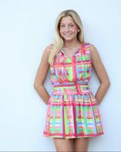 Load image into Gallery viewer, Woman wearing a colorful checkered dress against a light blue background