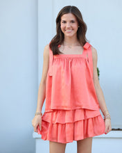 Load image into Gallery viewer, Woman wearing a coral dress against a light blue wall